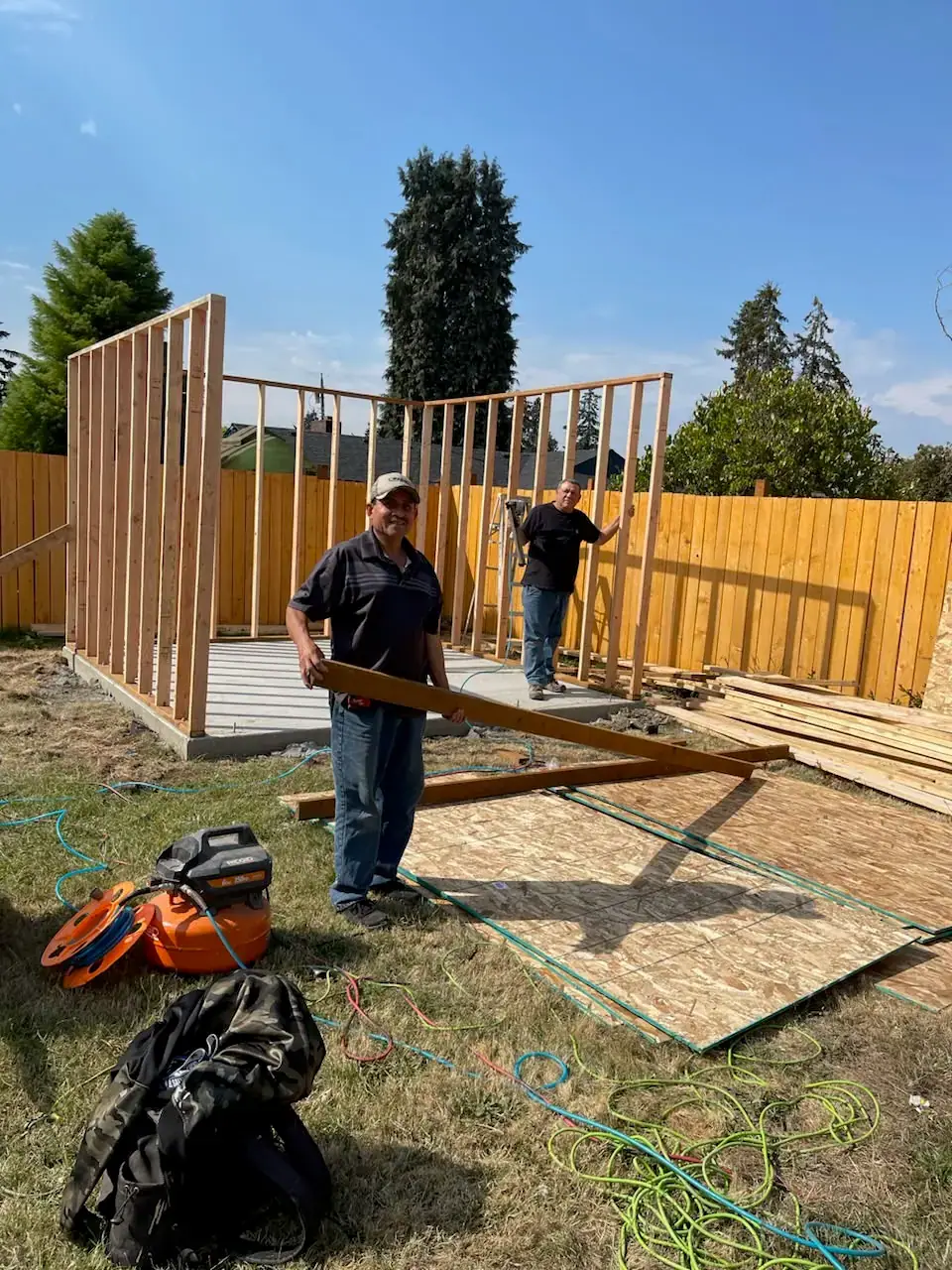 VMG Painting & Remodeling crew framing the walls of a new backyard structure on a concrete slab